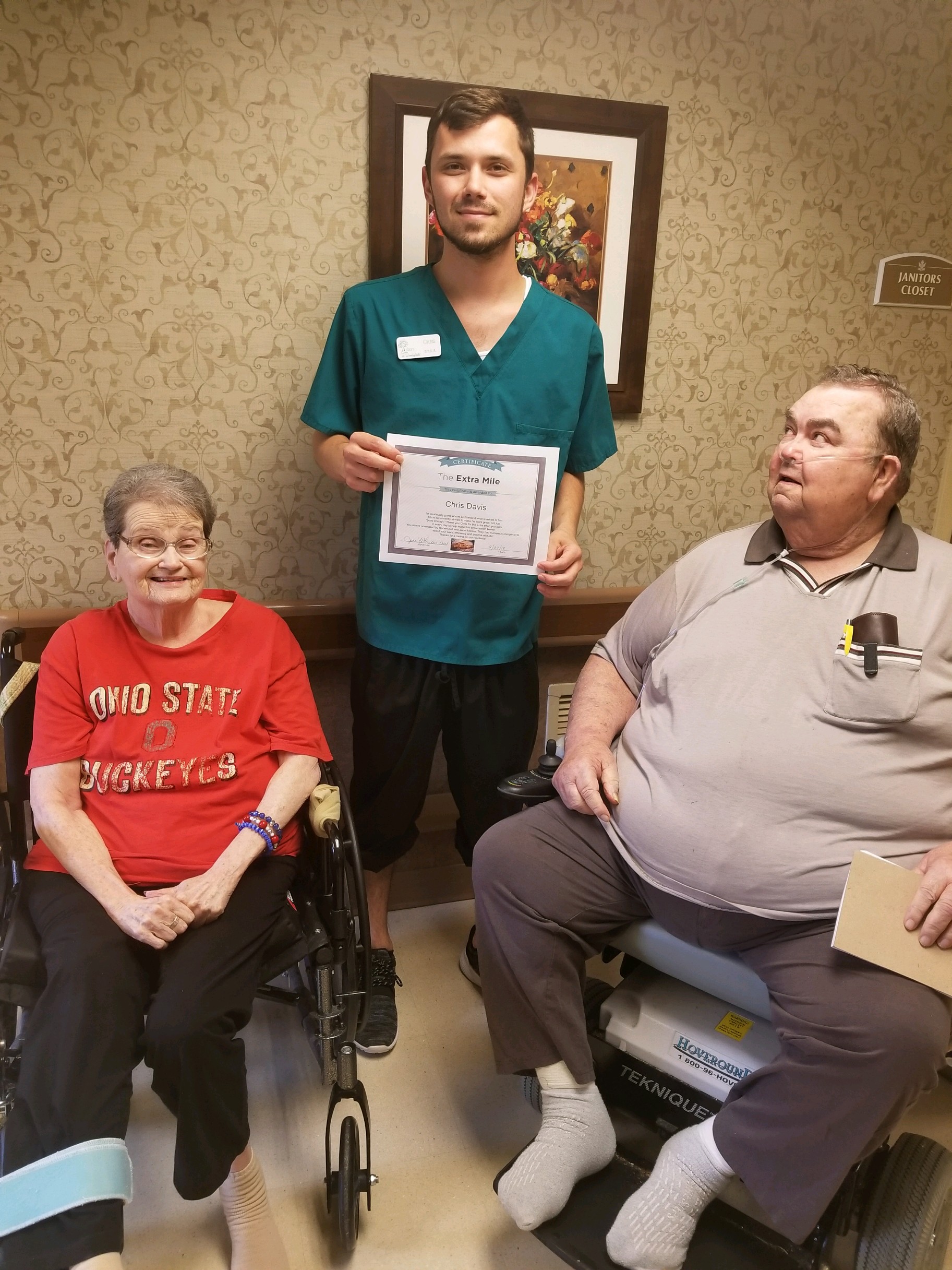 Chris David with Extra Mile Award and two residents